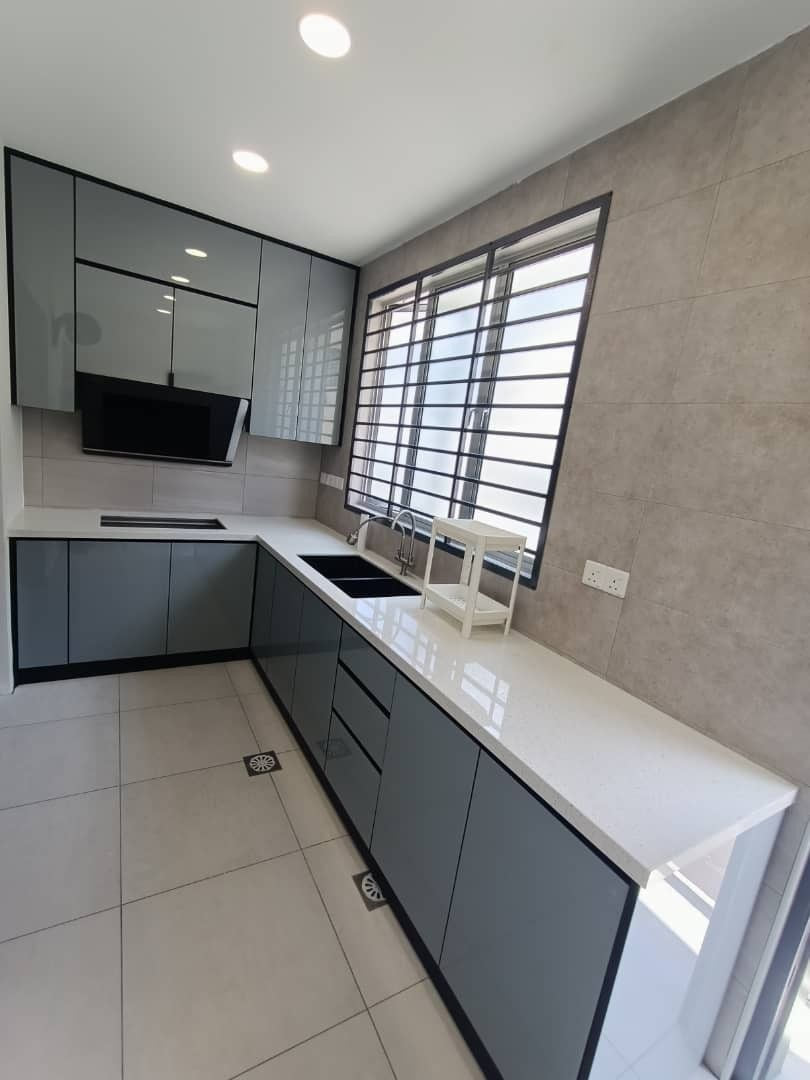A grey and charcoal kitchen run under a grilled window, with a microwave shelf and a bank of drawers.